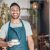 Portrait of one young hispanic waiter serving a cup of coffee while working in a cafe. Friendly barista and coffeeshop owner managing a successful restaurant startup